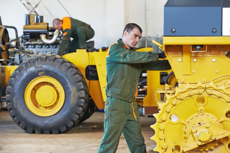A person standing next to a tractorDescription automatically generated with low confidence
